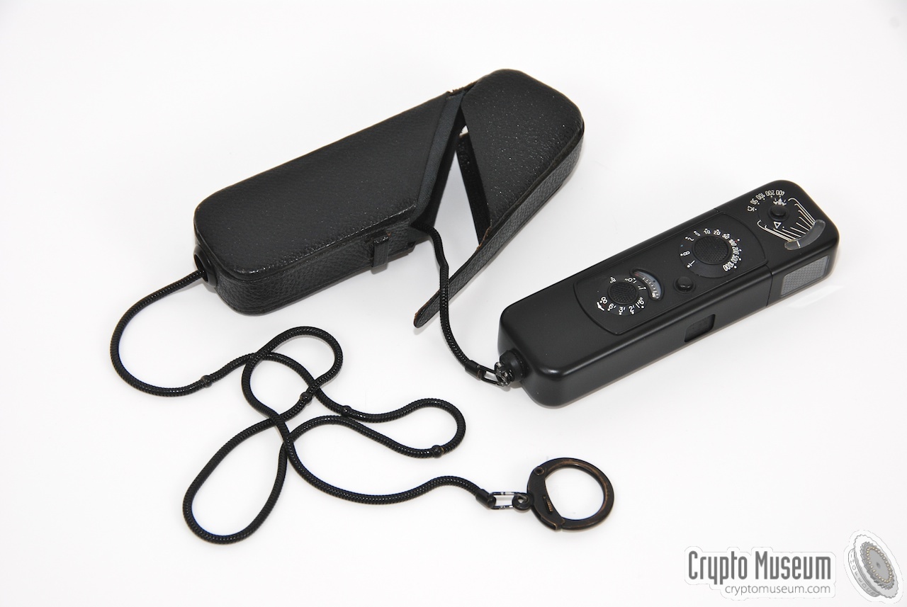 The black Minox-B with black measuring chain unpacked from its leather carrying pouch