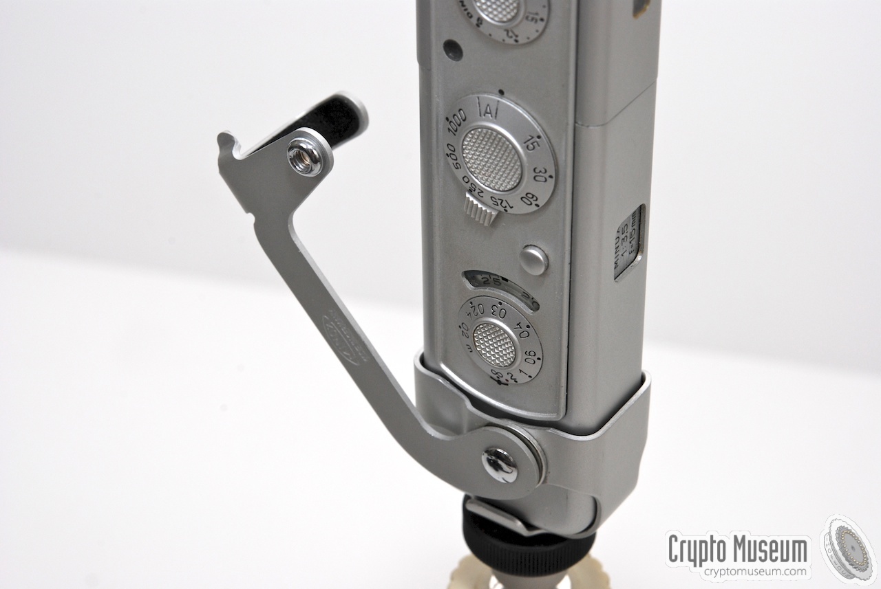A minox C camera mounted in the tripod adapter. A bracket allows the current release cable to reach the shutter button.