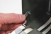 The spring-loaded bracket should mate with a pin in the top cover.
