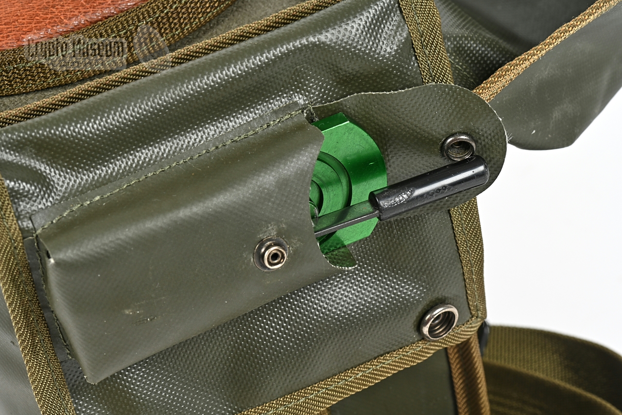 Pin-setting tool stowed in a pocket of the carrying bag