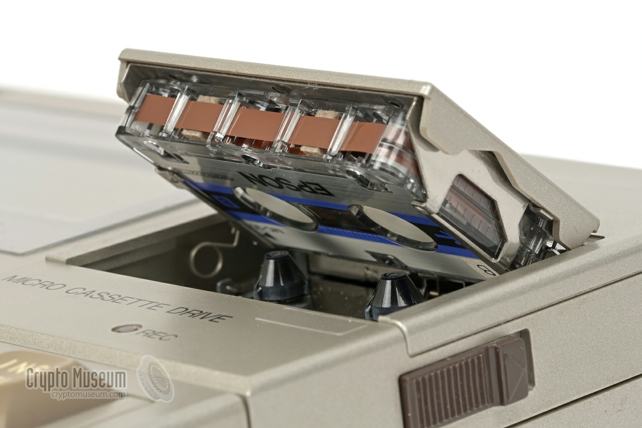 Microcassette being loaded into the built-in cassette recorder